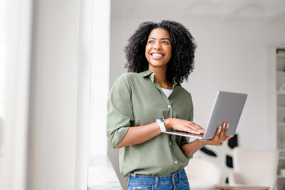 Radiant African-American woman casually handles laptop