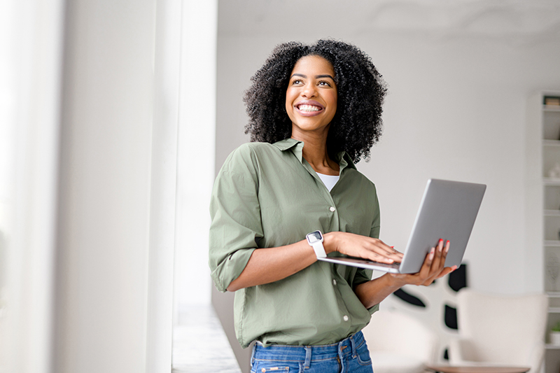 Radiant African-American woman casually handles laptop